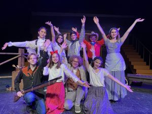 Teen actors from Kids On Stage pose on stage in costume after an Oklahoma musical theater performance.